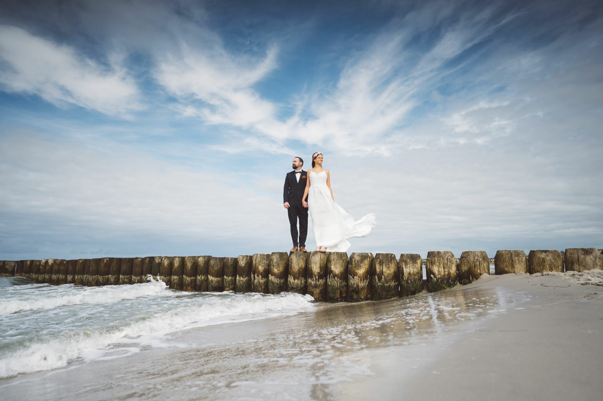 Ein Hochzeitspaar steht am Strand der Ostsee.